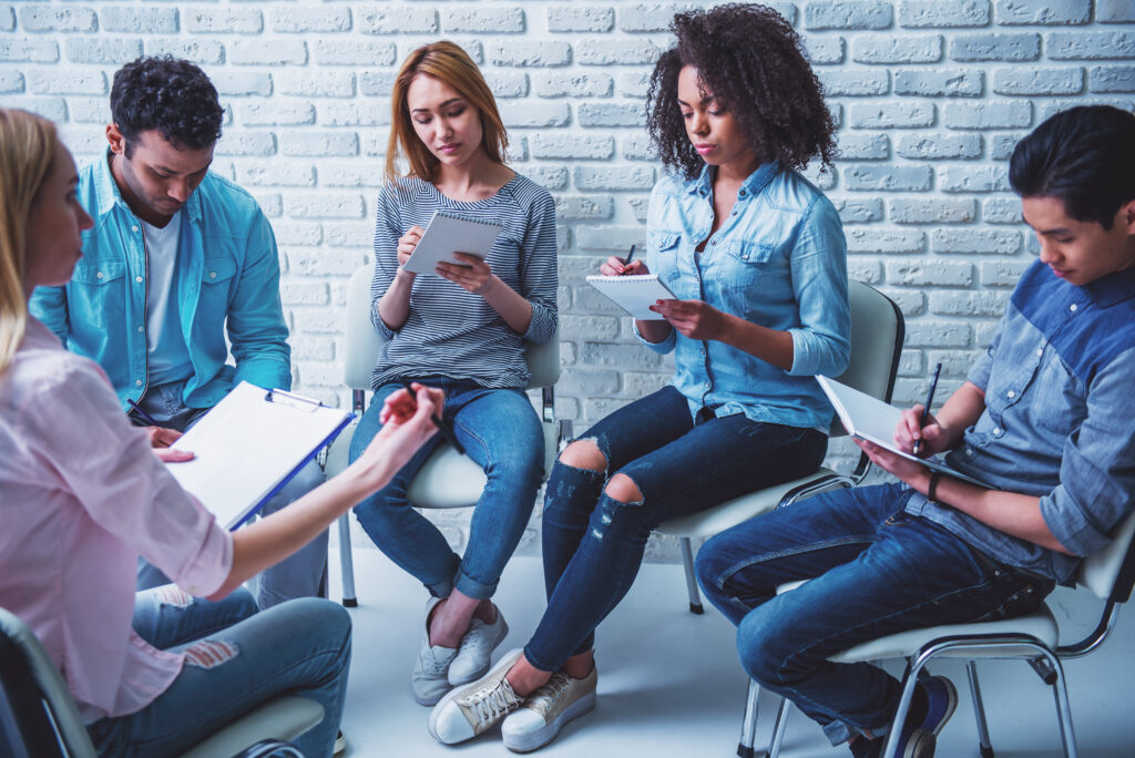 A group of people with notepads in a meeting